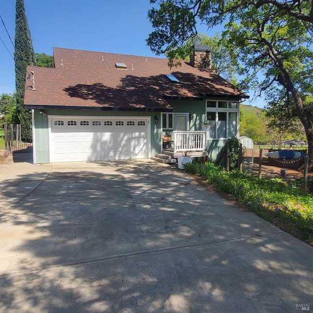 view of front of home featuring a chimney, fence, an attached garage, driveway, and roof with shingles