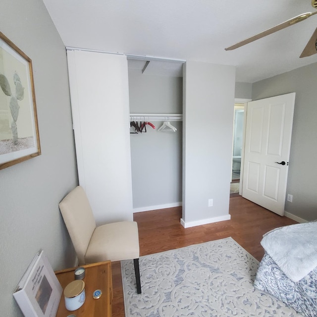 bedroom featuring baseboards, wood finished floors, and a closet