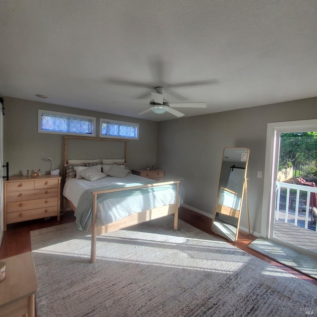bedroom featuring access to outside, multiple windows, and wood finished floors