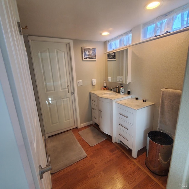 bathroom with recessed lighting, wood finished floors, and vanity