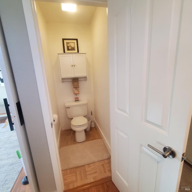 bathroom with baseboards and toilet