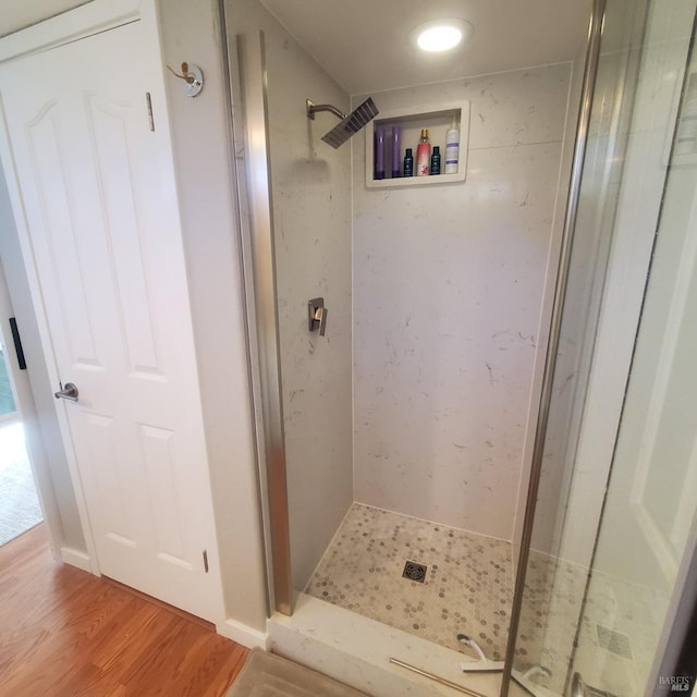 full bath featuring a shower stall and wood finished floors
