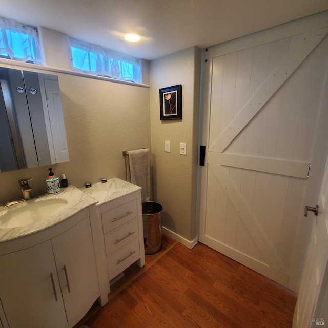 bathroom featuring vanity, baseboards, and wood finished floors
