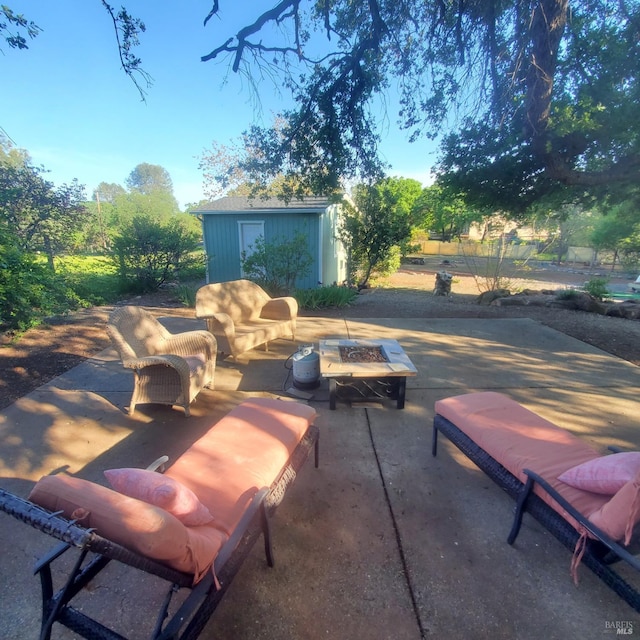 view of patio / terrace with a fire pit, an outbuilding, and a shed