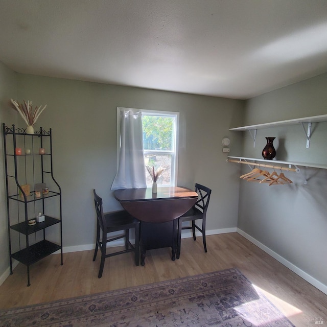 dining room featuring light wood finished floors and baseboards