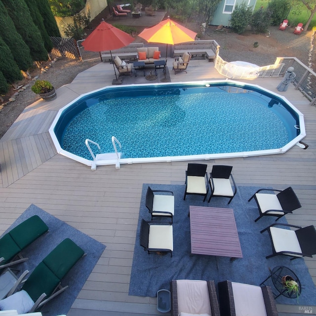 outdoor pool with a deck and an outdoor hangout area