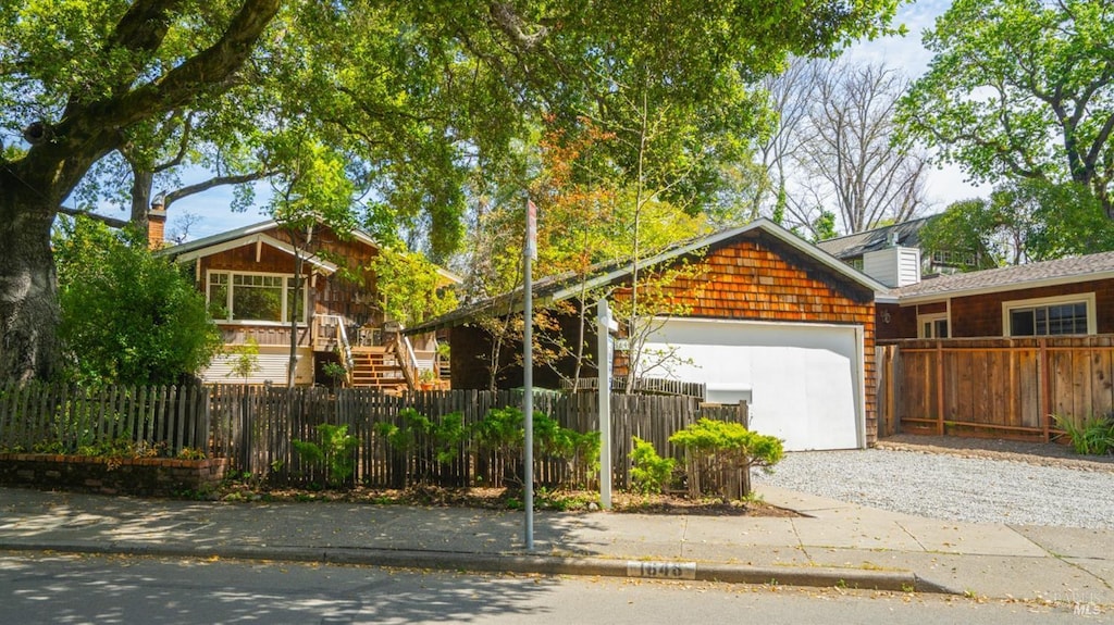 view of front of property with an attached garage, driveway, and a fenced front yard