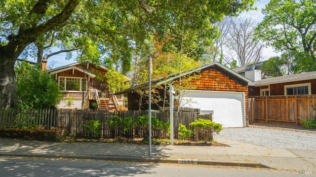view of front of property with an attached garage, driveway, and a fenced front yard
