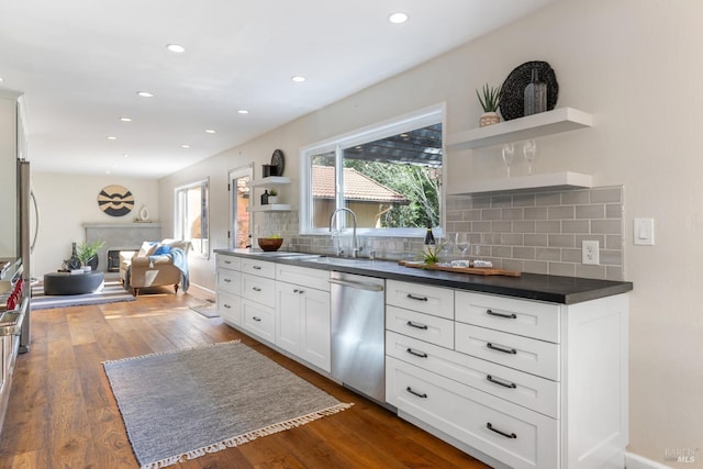 kitchen with white cabinets, open shelves, dishwasher, dark countertops, and backsplash