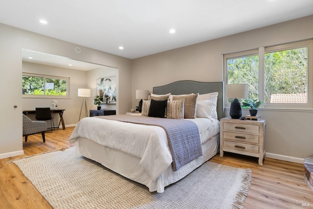 bedroom with light wood-type flooring, baseboards, and recessed lighting
