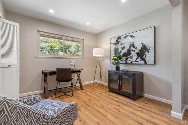 office space with baseboards, light wood-type flooring, and recessed lighting