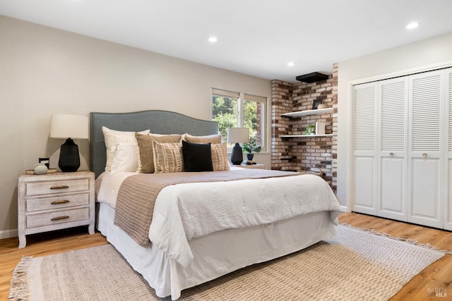bedroom with a closet, baseboards, light wood finished floors, and recessed lighting