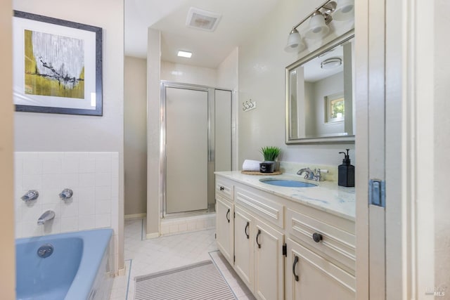 full bath featuring a shower stall, a garden tub, vanity, and tile patterned flooring
