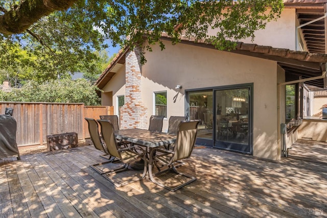wooden deck with outdoor dining space and fence