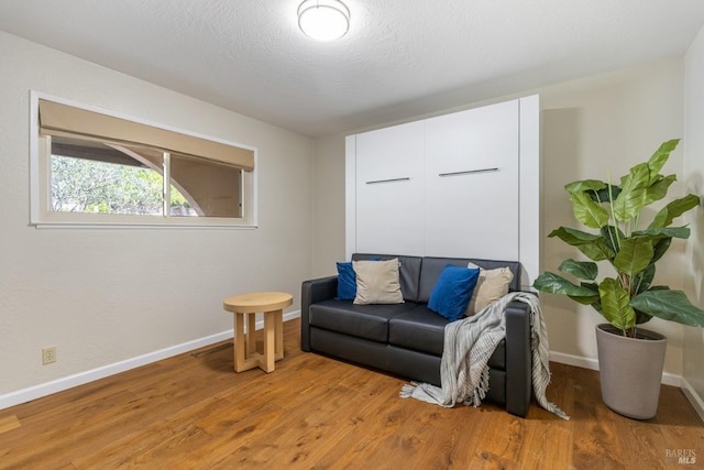 living area featuring light wood-type flooring and baseboards