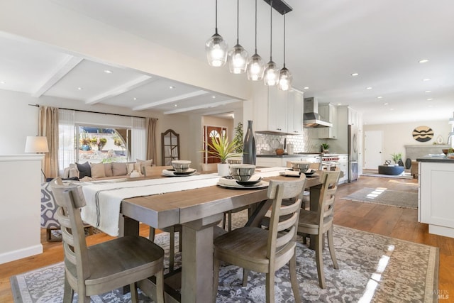 dining space with light wood-style floors, baseboards, beam ceiling, and recessed lighting