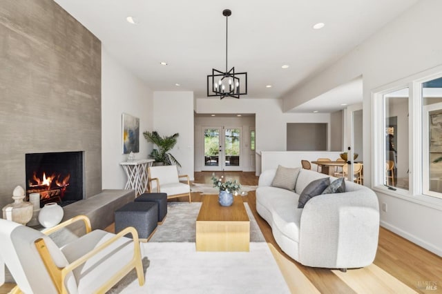 living room featuring a high end fireplace, french doors, wood finished floors, and recessed lighting