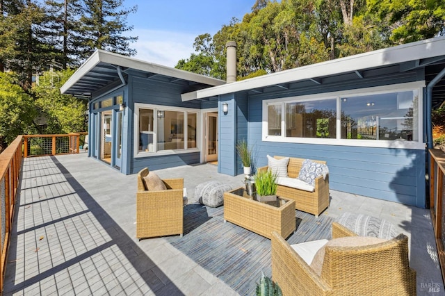 wooden terrace with an outdoor living space