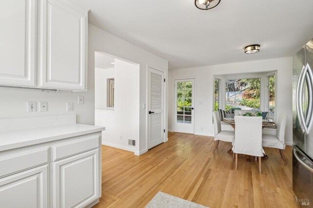 dining area featuring light wood-style floors and baseboards