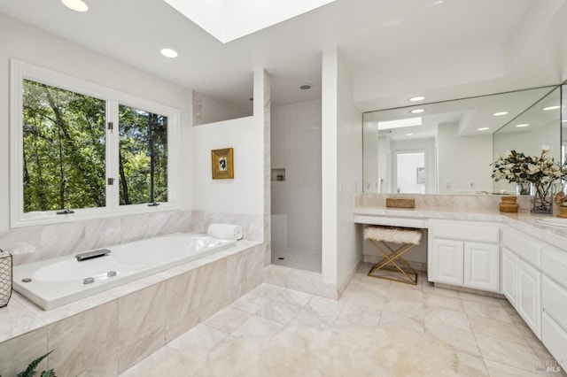 bathroom with a garden tub, a skylight, vanity, a tile shower, and recessed lighting