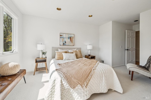 bedroom featuring visible vents, light carpet, and baseboards