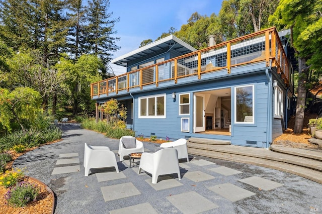 back of property with crawl space, a patio, a balcony, and an outdoor living space