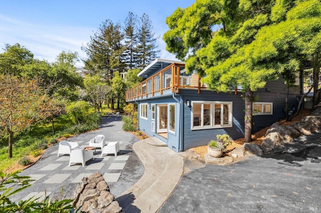 rear view of house featuring a patio area and a balcony