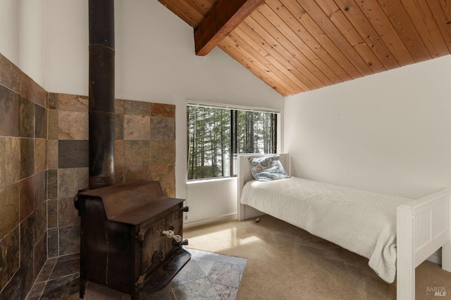 bedroom featuring a wood stove, vaulted ceiling with beams, wooden ceiling, and carpet
