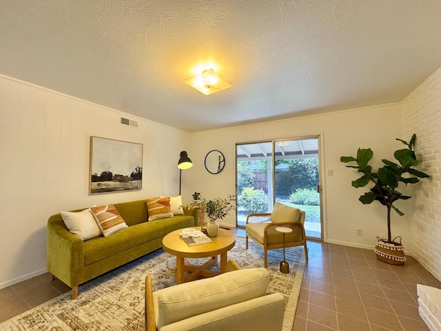 living room featuring tile patterned floors, visible vents, a textured ceiling, and baseboards