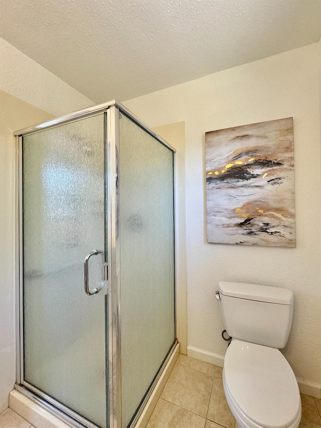 bathroom with baseboards, a shower stall, toilet, and tile patterned flooring