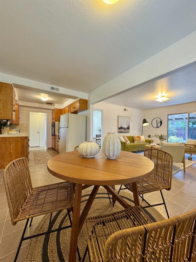 dining area featuring light tile patterned floors and visible vents