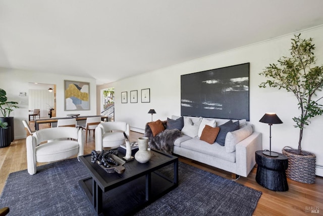 living room featuring baseboards, a baseboard heating unit, and wood finished floors