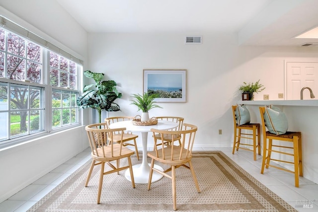 dining space featuring light tile patterned floors, baseboards, and visible vents