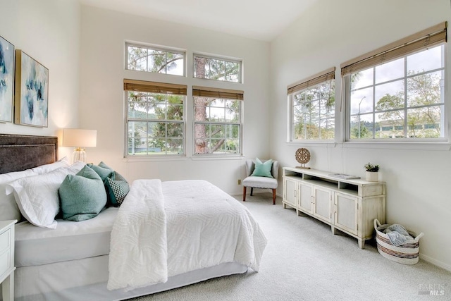 bedroom with light carpet and multiple windows