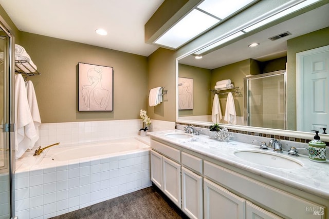 bathroom with visible vents, a shower stall, a sink, and a garden tub