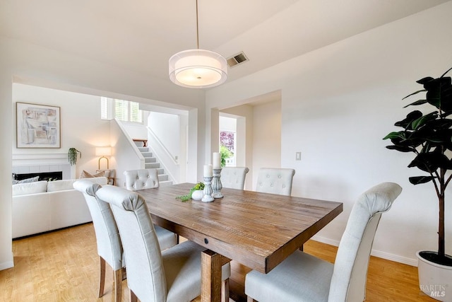 dining space featuring stairs, visible vents, a healthy amount of sunlight, and light wood-style flooring