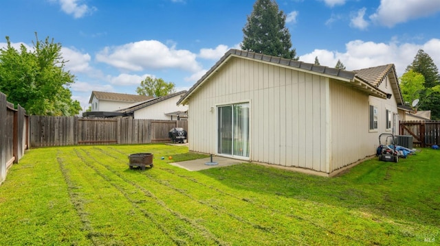 1864 Quail Meadows Cir, Vacaville, CA 95687 - back of house with cooling unit, a yard, a fenced backyard, and a fire pit