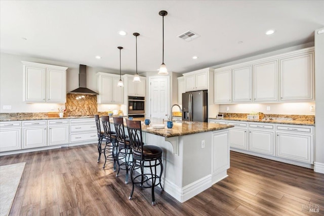 1012 Capitola Ct, Vacaville, CA 95687 - kitchen with wall chimney range hood, stainless steel appliances, white cabinetry, dark wood-style floors, and an island with sink