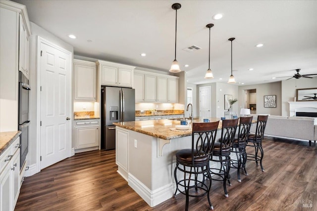 1012 Capitola Ct, Vacaville, CA 95687 - kitchen featuring stainless steel refrigerator with ice dispenser, dark wood finished floors, recessed lighting, open floor plan, and a breakfast bar area