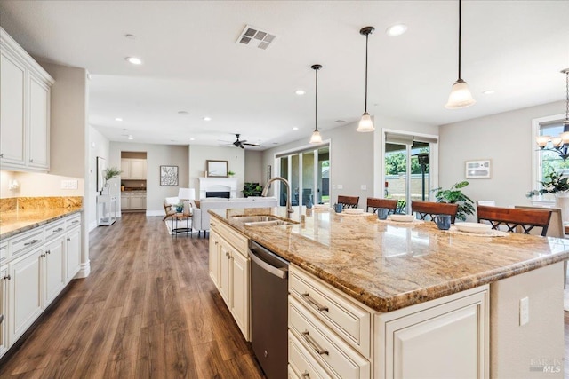 1012 Capitola Ct, Vacaville, CA 95687 - kitchen featuring stainless steel dishwasher, wood finished floors, a fireplace, a ceiling fan, and plenty of natural light