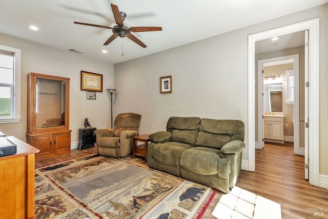 living area featuring visible vents, baseboards, ceiling fan, light wood-type flooring, and recessed lighting
