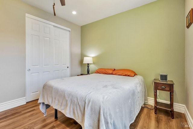 bedroom with wood finished floors, baseboards, a closet, and recessed lighting