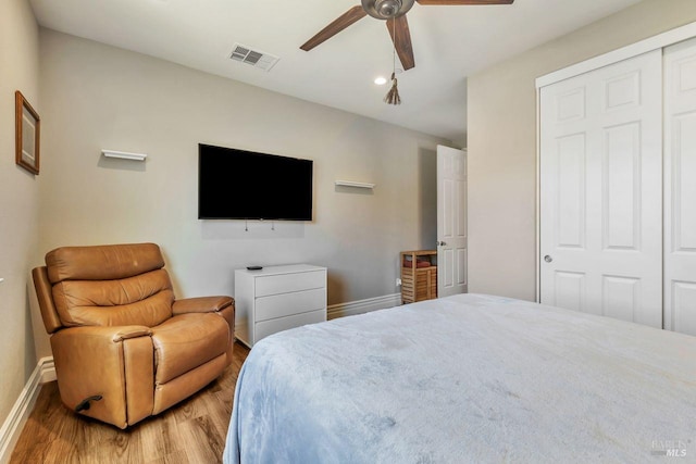 bedroom featuring visible vents, baseboards, a closet, ceiling fan, and light wood finished floors