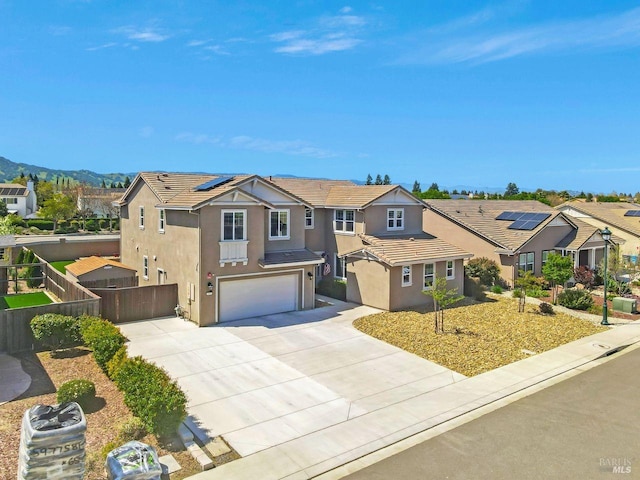 traditional-style home featuring a tiled roof, a garage, stucco siding, and fence