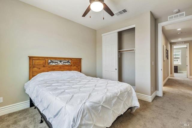 bedroom with a closet, visible vents, light colored carpet, and baseboards