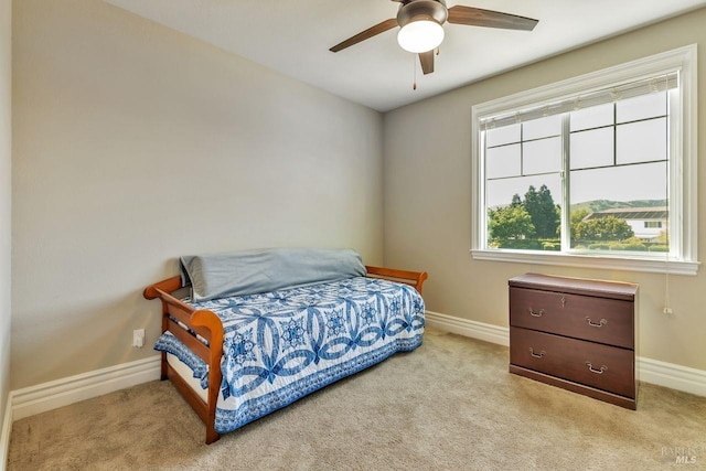bedroom featuring light carpet, baseboards, and a ceiling fan