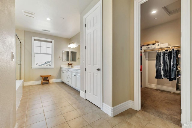 bathroom with visible vents, baseboards, vanity, tile patterned floors, and a stall shower