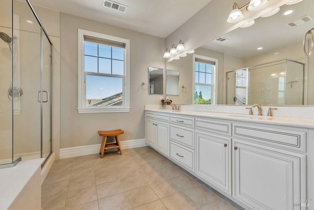 bathroom featuring a shower stall, double vanity, visible vents, and a sink