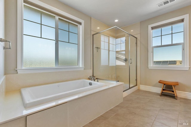 full bathroom with a wealth of natural light, visible vents, a shower stall, and a bath