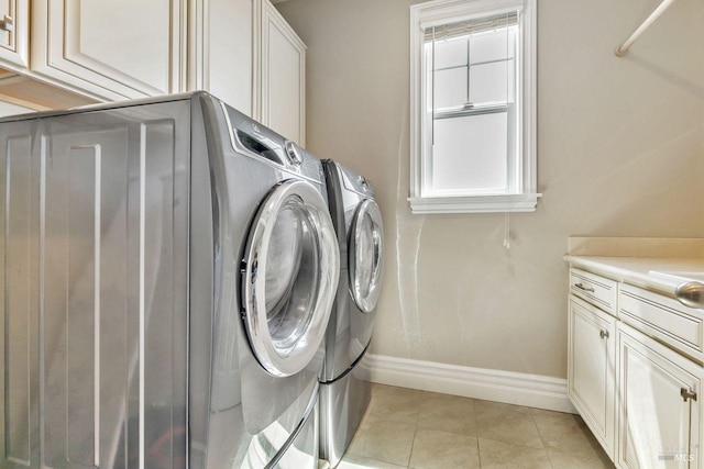 laundry room with independent washer and dryer, light tile patterned floors, baseboards, and cabinet space